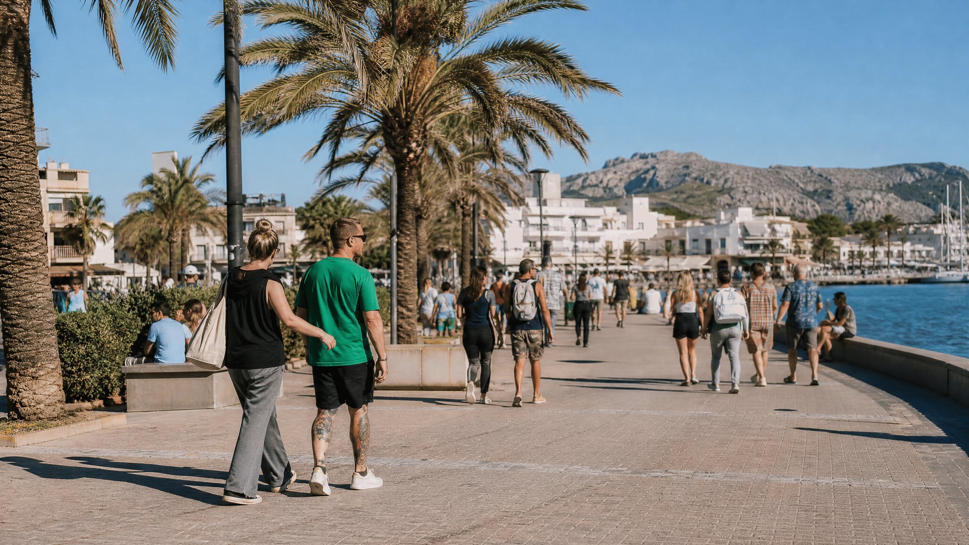 Frente marítimo de Port d’Alcúdia con vecinos paseando cerca del contexto de club social de cannabis