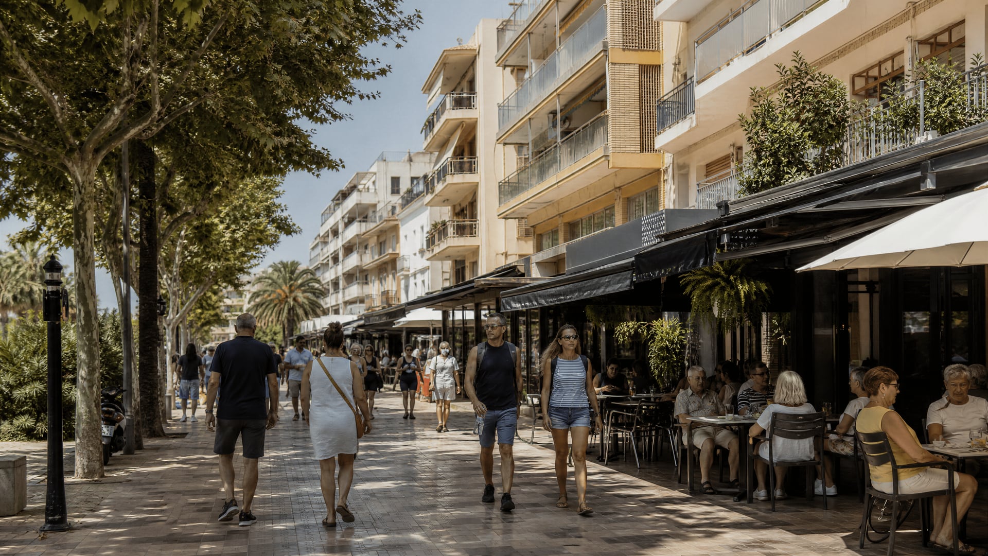 Rua residencial de Salou com moradores a passar por cafés e apartamentos