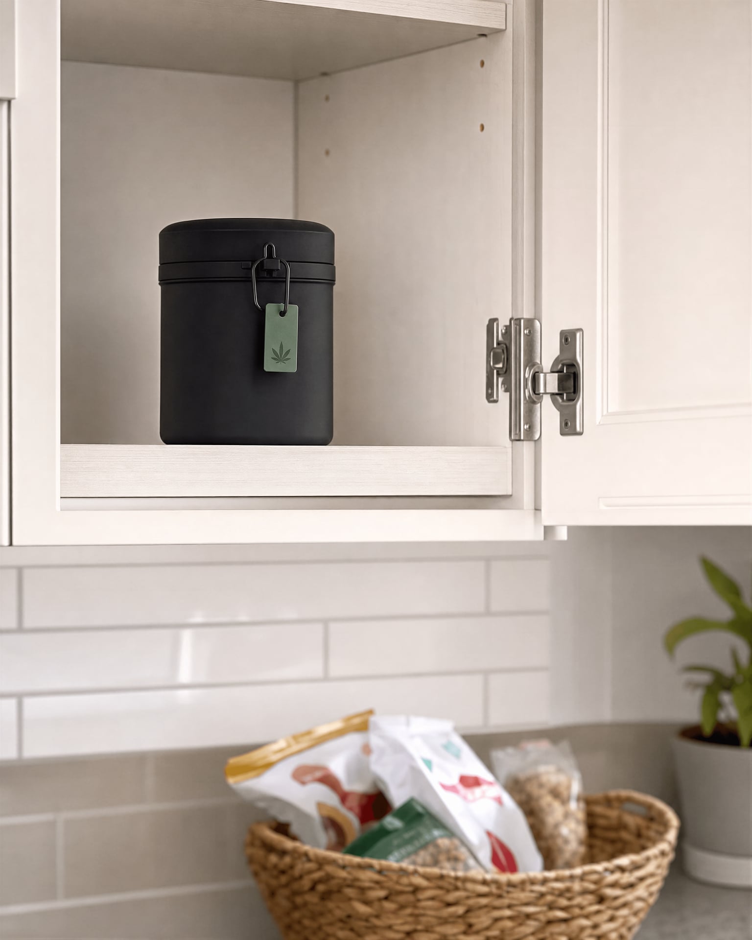 Child-resistant cannabis storage kept high in a kitchen cabinet away from snacks.