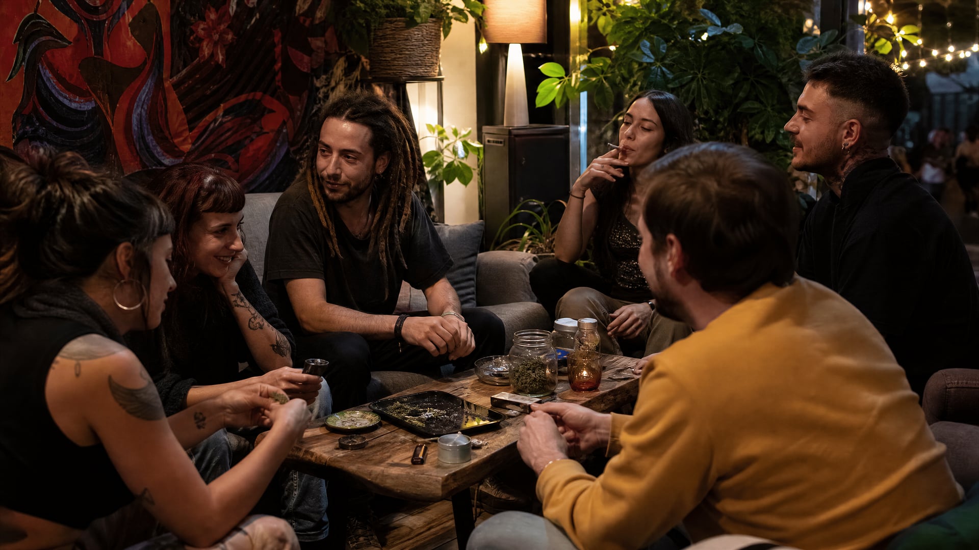 Members gathered in a cozy Madrid cannabis social club lounge at night