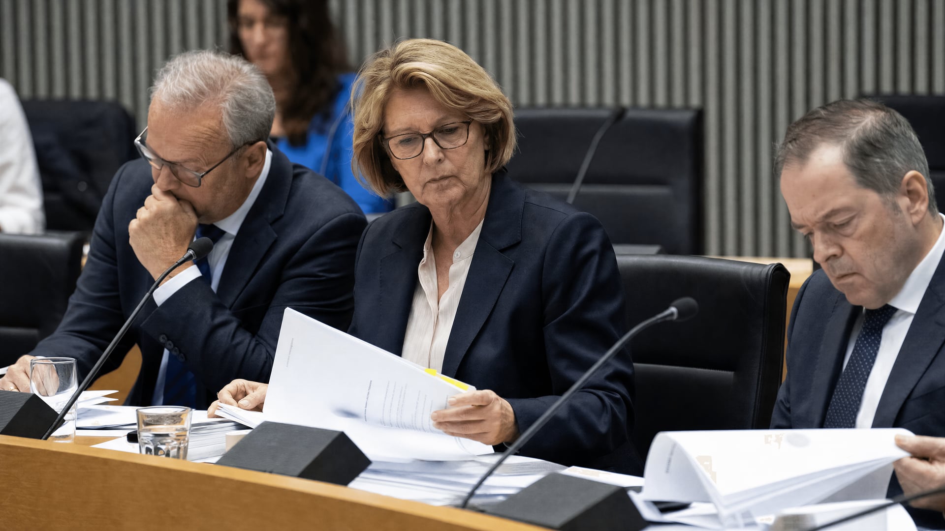 A German Bundestag health committee hearing room with microphones and draft legislation on medical cannabis.