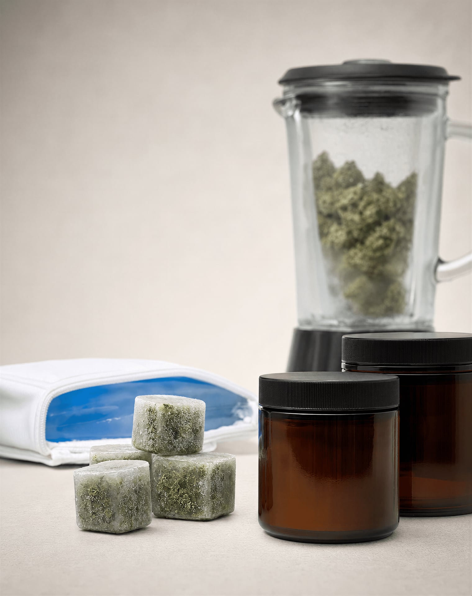 Frozen cannabis portions and opaque airtight containers arranged for cold processing.