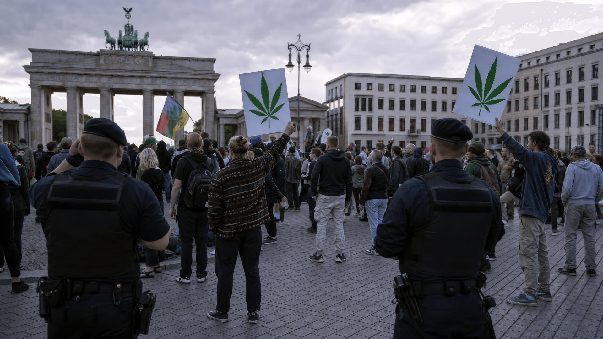 경찰의 감시 아래 Cannabis 법 표지판을 든 시위대가 있는 베를린의 공공 광장