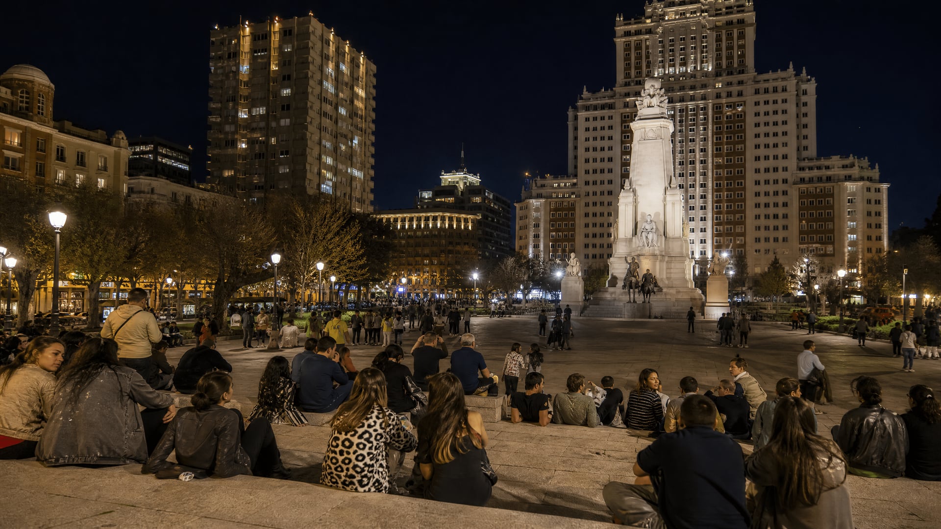 Plaza de España at night with Madrid city lights and social club context